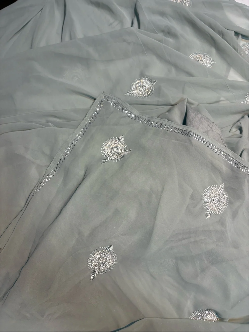 218” Legnth sage green draped saree features delicate silver embroidery